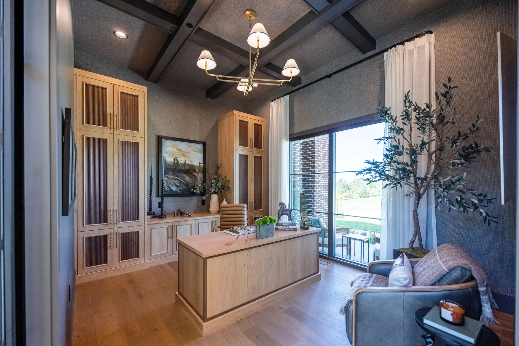 Chalet De' Roubaix home office with oak cabinetry, dark beamed ceiling, and garden-facing glass doors
